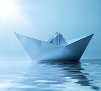 concept paper ship in water and sunny blue sky