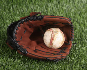Baseball and glove laying on the grass