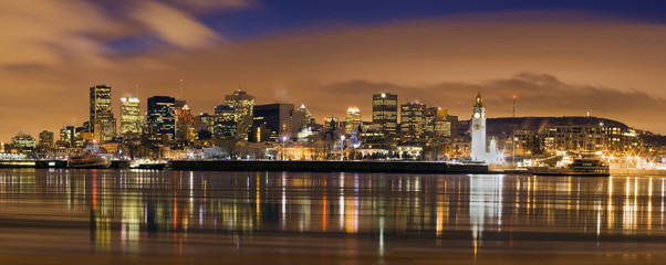 Fototapeta premium downtown skyline panorama at dusk in Montreal Canada with river