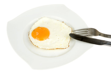 an egg on a plate with a fork and knife