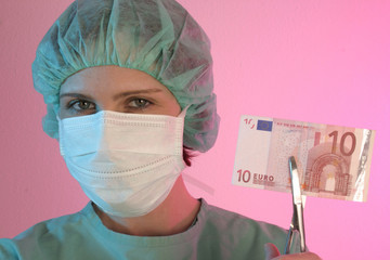 Eine Frau mit Mundschutz in grüner Kleidung einer Medizinerin mit Banknote vor rosa Hintergrund