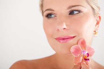 Young beautiful woman with clean healthy skin and orchid