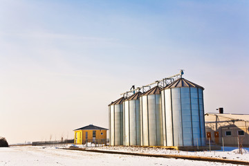 beautiful landscape with silo and snow white acre with blue sky