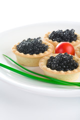 Tartlet with black caviar on a white platter