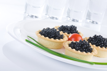 Tartlet with black caviar on a white platter