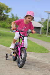 Fillette sur un vélo avec des roulettes