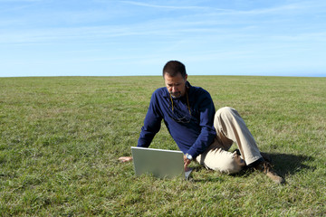 Mature man using laptop in field