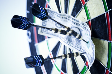 Darts target and dollar in bull's-eye