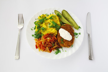 dinner plate with meal served with knife and fork