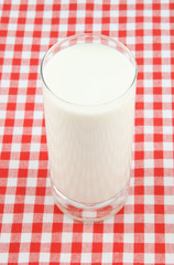 Glass cup of milk on tablecloth