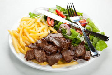 Grilled meat with fried potatoes and vegetables