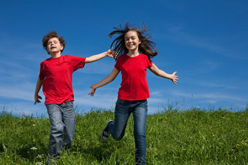 Fototapeta premium Girl and boy jumping, running outdoor