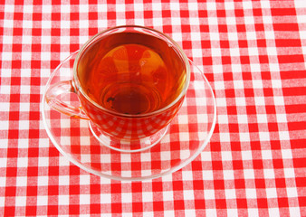 Glass cup of tea on tablecloth