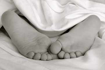 Füße im Bett schwarz weiss