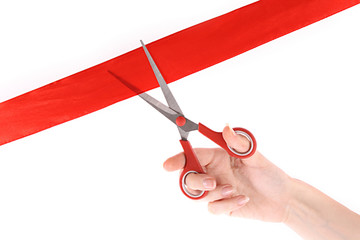 Red ribbon, scissors and hand isolated on white.