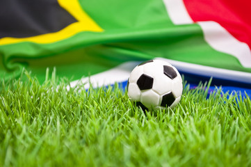 Fußball auf einer Wiese mit Südafrikafahne