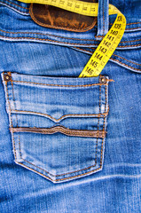 Blue jeans and measure tape in pocket - concept of overweight