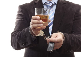 Businessman chained in handcuffs with keys and drink
