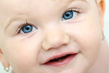 Detailed face of beautiful blue-eyed baby girl taking bath
