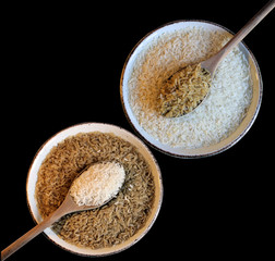 White and brown Rice with Wooden spoon on black