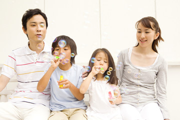 シャボン玉で遊ぶ家族