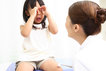 怪我をした女の子に消毒をする看護師
