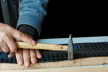construction worker nails insulation film on plank (isolated)