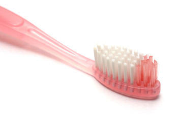 closeup on a pink tooth brush. white background