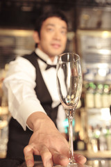 カクテルをサービスするバーテンダー