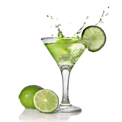 Green alchohol cocktail with splash and green lime