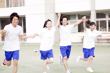 手をつなぎはしゃぐ高校生