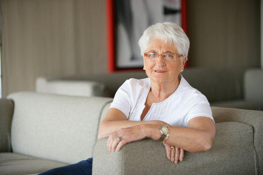 Portrait d'une femme senior assise sur un canapé