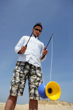 Homme jouant avec un diabolo &agrave; la mer
