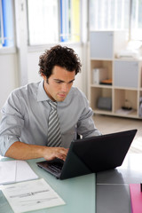 Homme en costume de devant ordinatuer portable