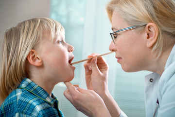 female doctor examining little child boy