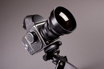 Old photo camera with tripod on grey in Hi-Res