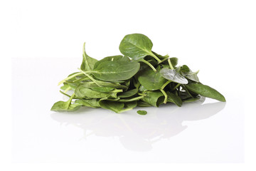 fresh spinach leaves on reflective white surface