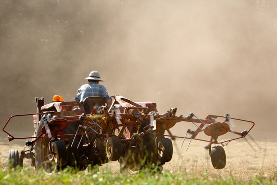 A tractor turning the freshly cut hay, Dordogne, France.