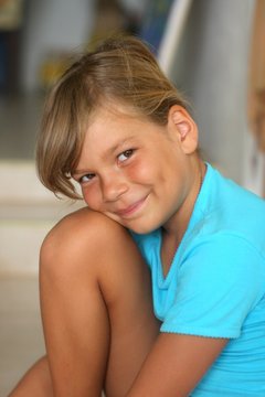 petite fille espiegle au T-shirt bleu
