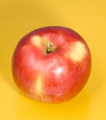 Red apple on a yellow background