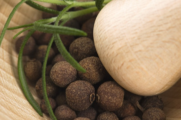 Mortar with fresh herbs and allspice berries