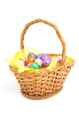 cane basket with easter eggs over white background