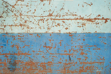 Striped two-tone painted blue metal surface with rust scrapes