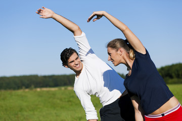 Paar dehnt sich vor dem Sport im Sommer