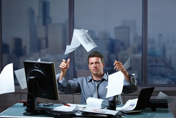 Businessman throwing documents into air