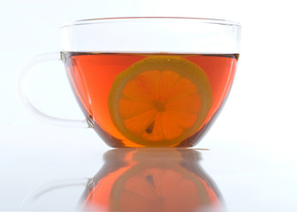 Glass cup of tea with lemon on a white background