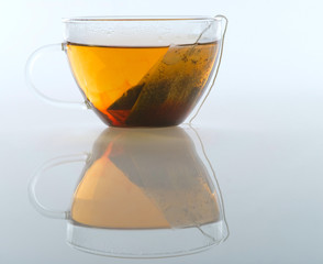 Glass cup of tea on a white background