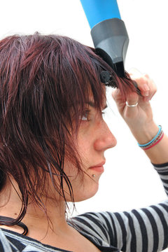 Chica secandose el pelo y peinandose