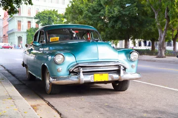Fotobehang Cubaanse oldtimers Metallic groene oldtimer auto in de straten van Havana