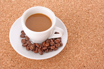 Small white  cup of coffee with coffee grain   on brown backgrou
